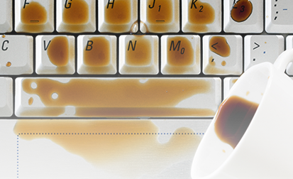 cup of coffee spilling on a keyboard