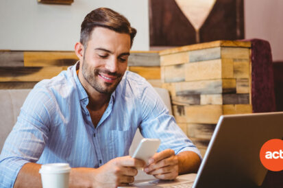 man working on a laptop with the act! Crm logo